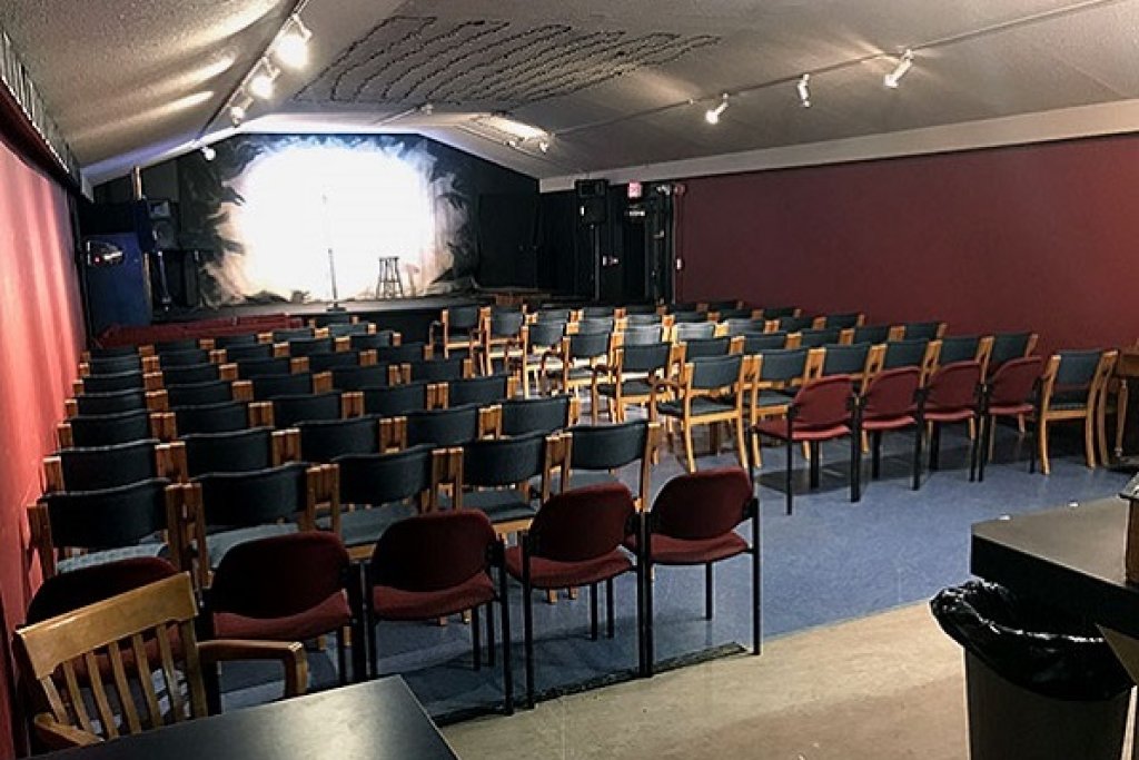A raised stage with rows of chairs lined up in front of it