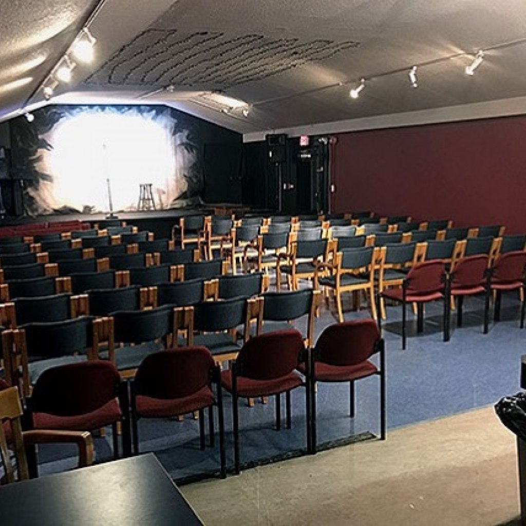 A raised stage with rows of chairs lined up in front of it
