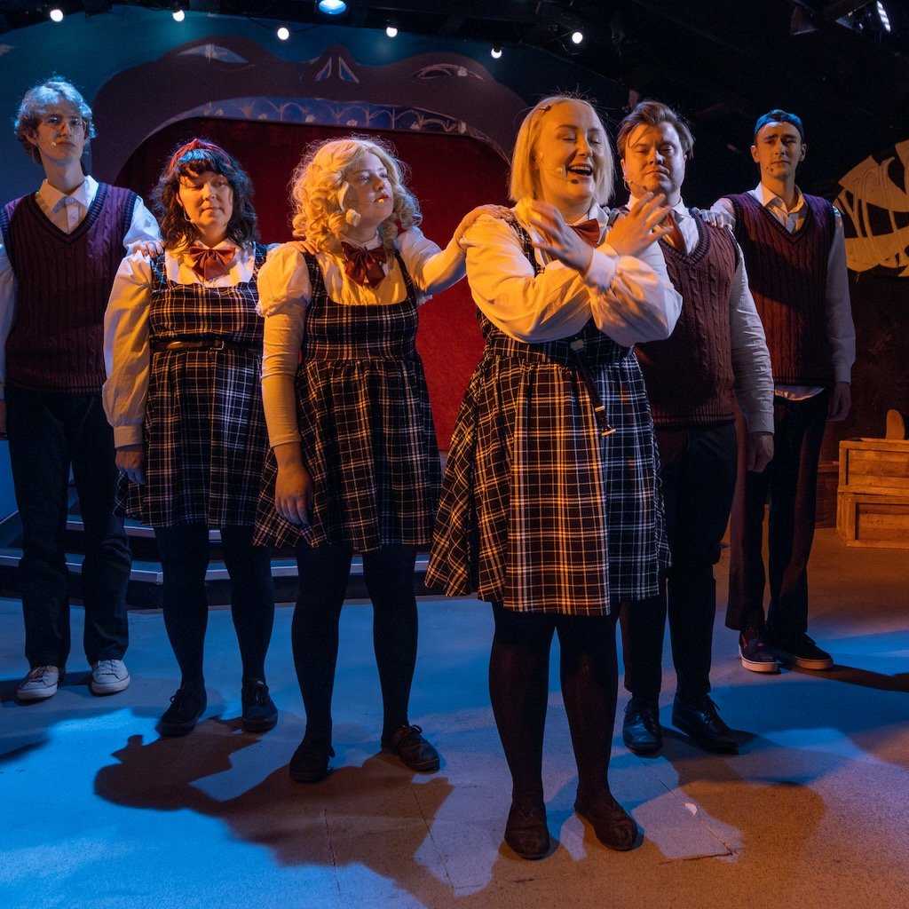 Archive photo of Ride the Cyclone. A young woman singing in front of the rest of the cast.