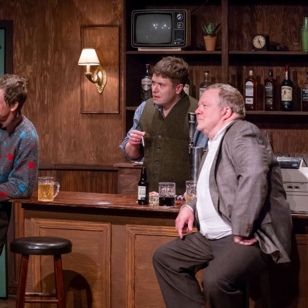 Two patrons and bartender at a bar, holding cigarettes
